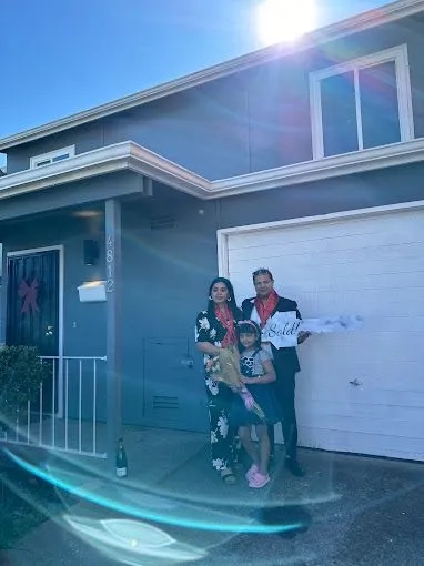 Family celebrating outside their newly purchased home