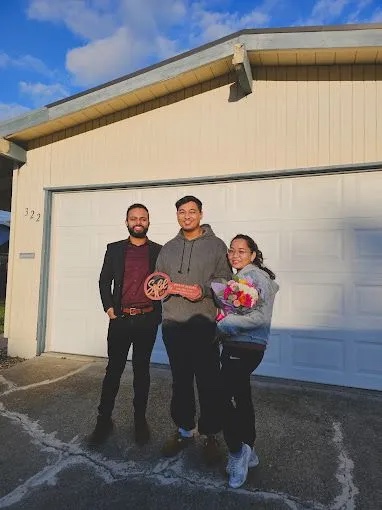 Clients with their Sold sign on closing day